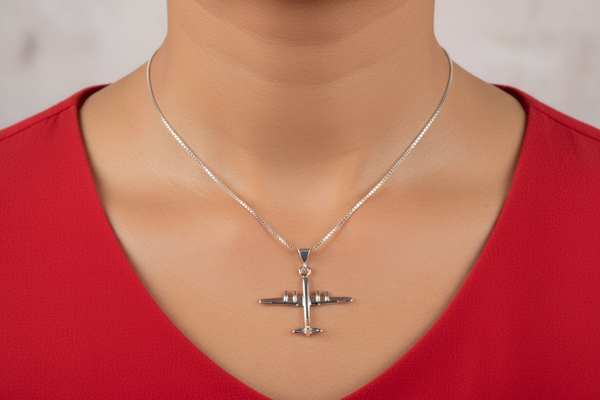 Silver airplane pendant necklace on a model with a red top