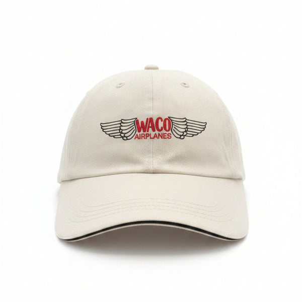 White cap with Waco Airplanes logo on a black surface